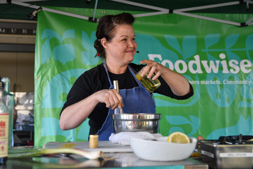 A person cooks at the farmers market