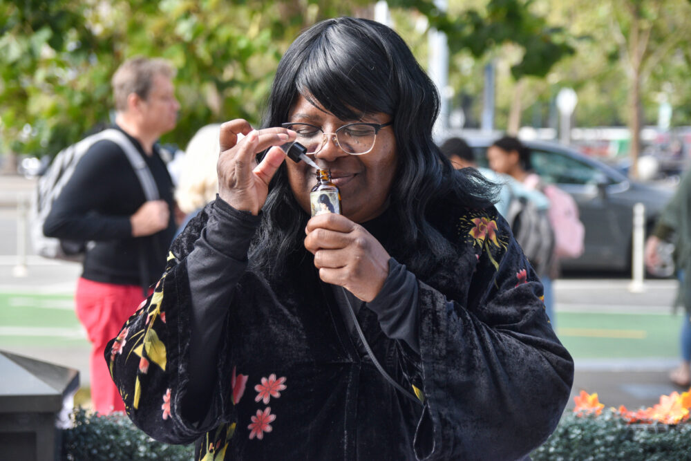 Kim Leonard poses while smelling one of En Vie Naturals aromatherapy products at Foodwise's farmers market in San Francisco