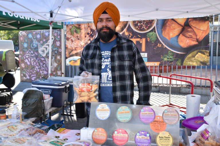 A person holding food at ROTI's stand at Foodwise's Mission Community Market