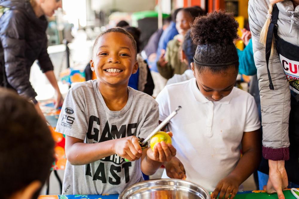 A young boy zesting a lemon as part of the Foodwise Kids program